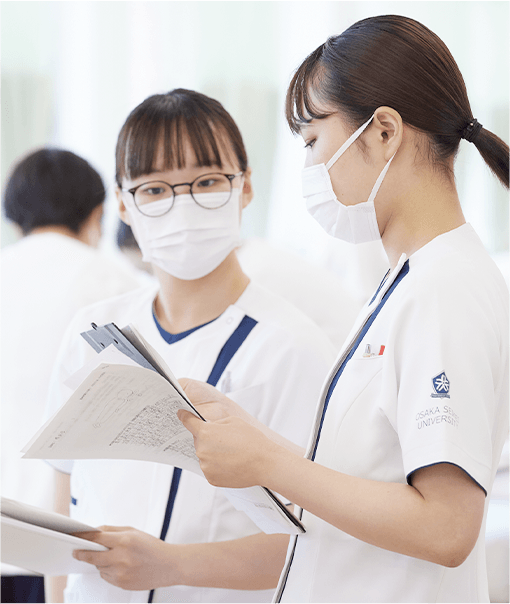 看護学生が資料を見ながら確認している様子